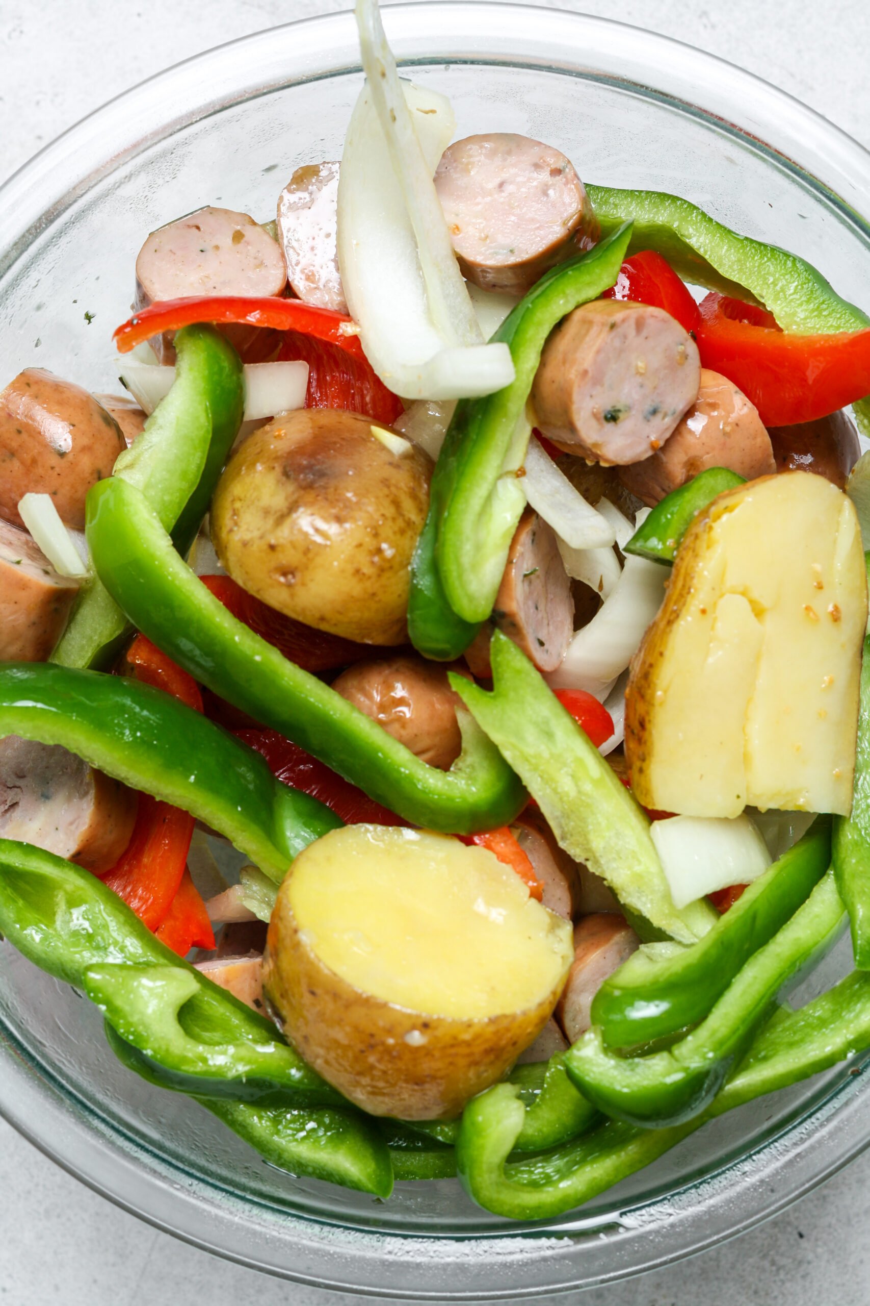 Glass bowl with sausage and veggies.