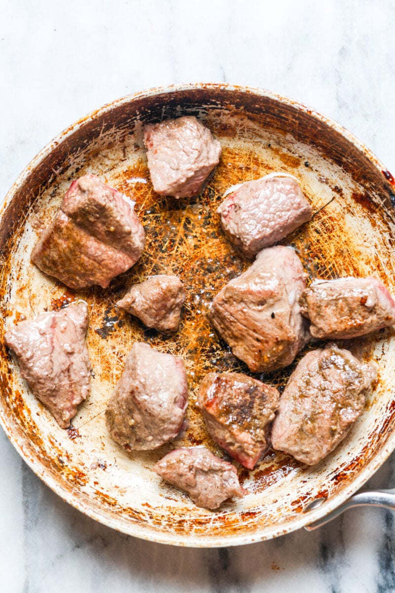 Seared beef in skillet.