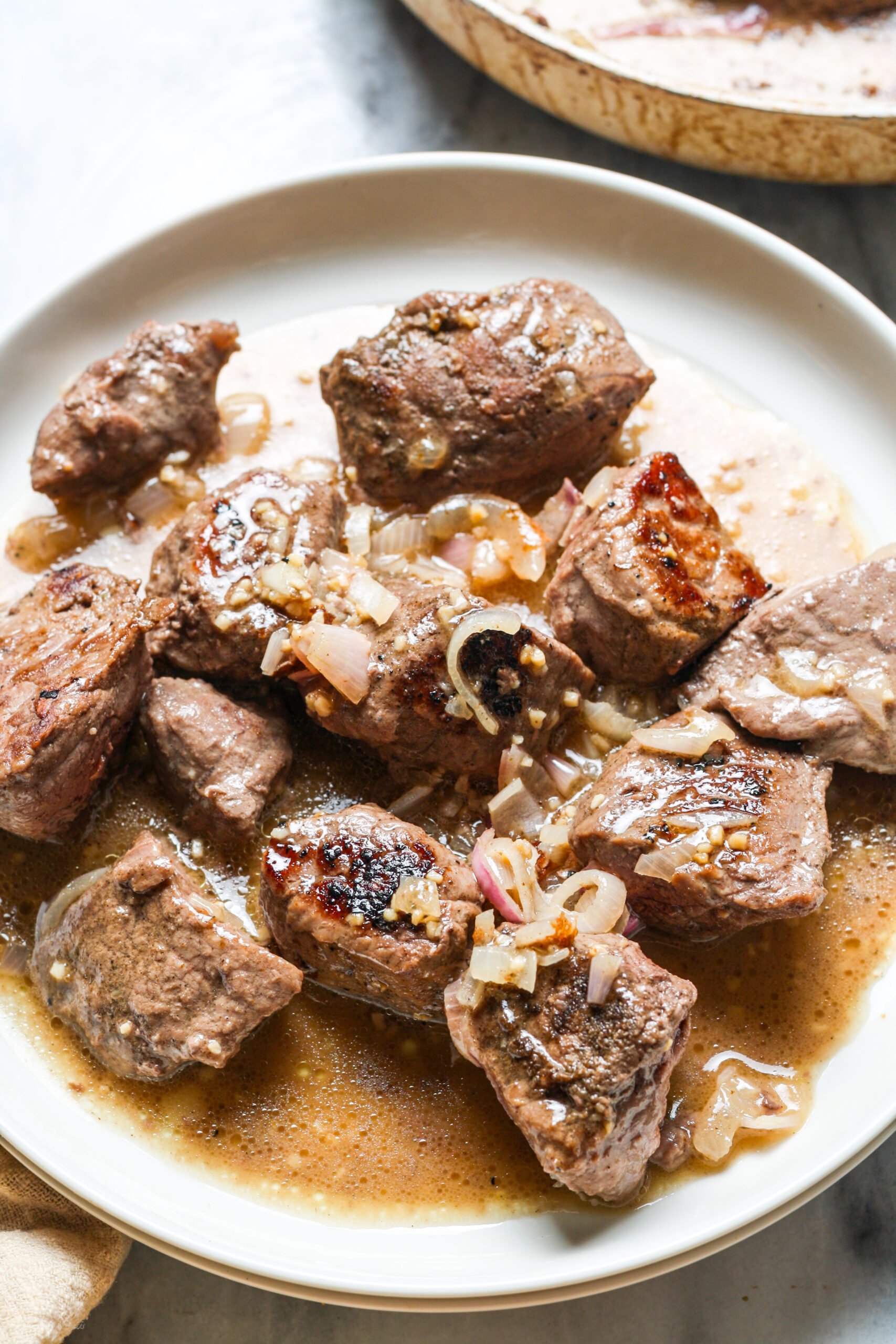White plate with seared beef.