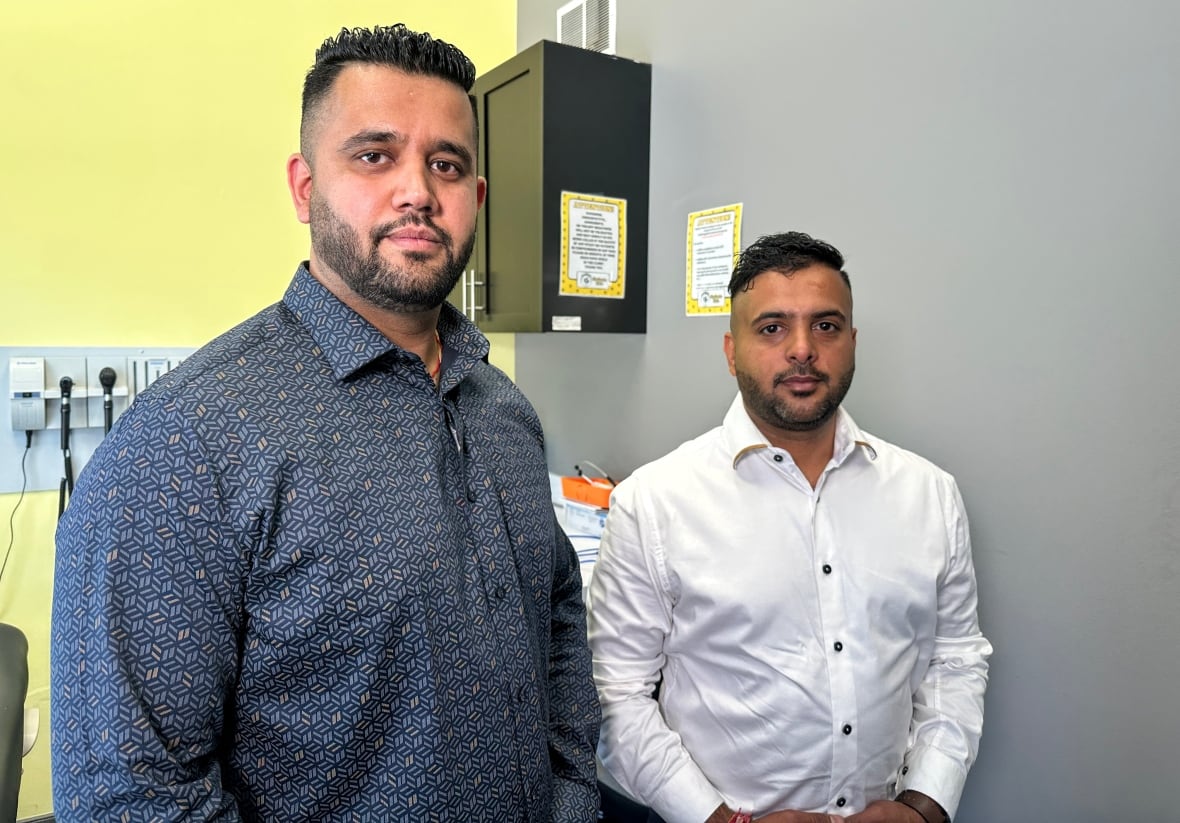 2 men stand in a clinical room.