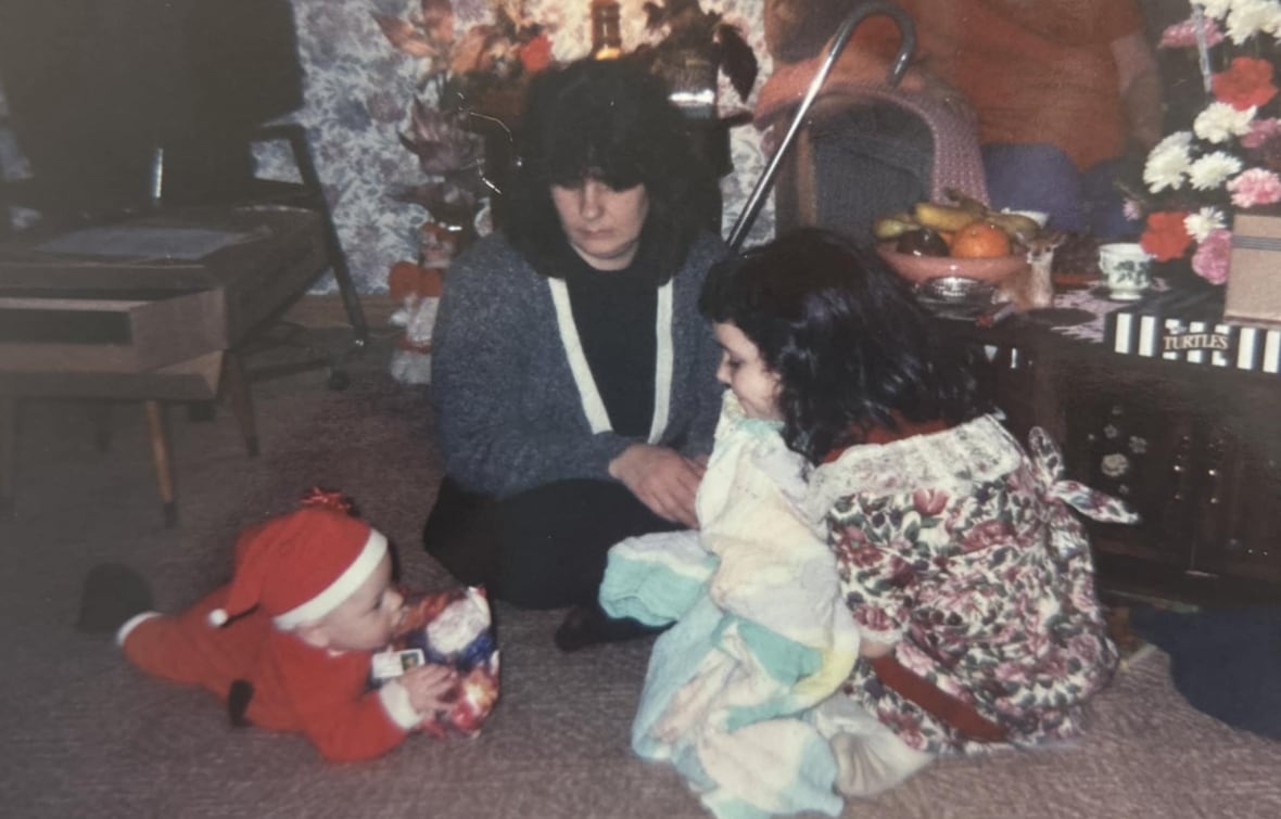 An old photograph shows a woman and two kids with Christmas decorations